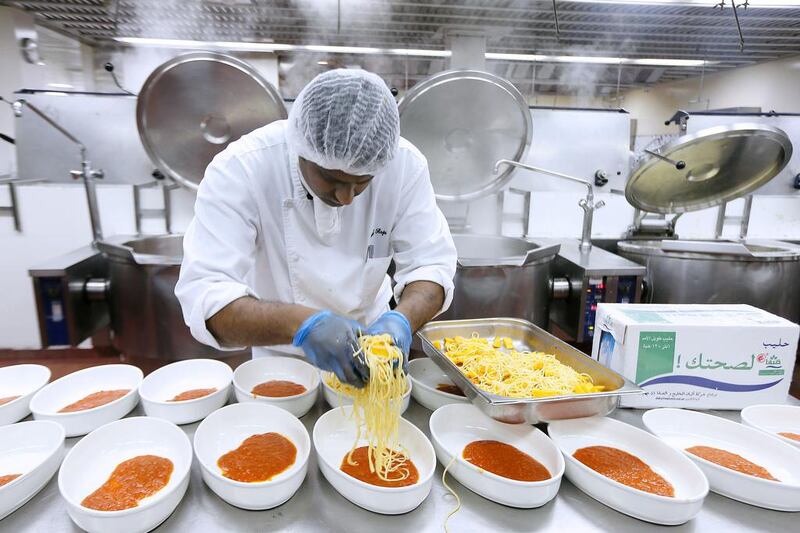 A cook prepares food inside the kitchen at Dubai World Trade Centre in Dubai. Pawan Singh / The National
