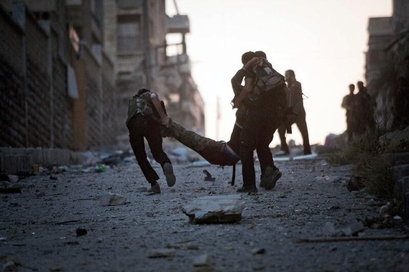 FSA soldiers carry their severely wounded colleague after being shot by a Syrian Army sniper in Izaa district. Manu Brabo / AP Photo