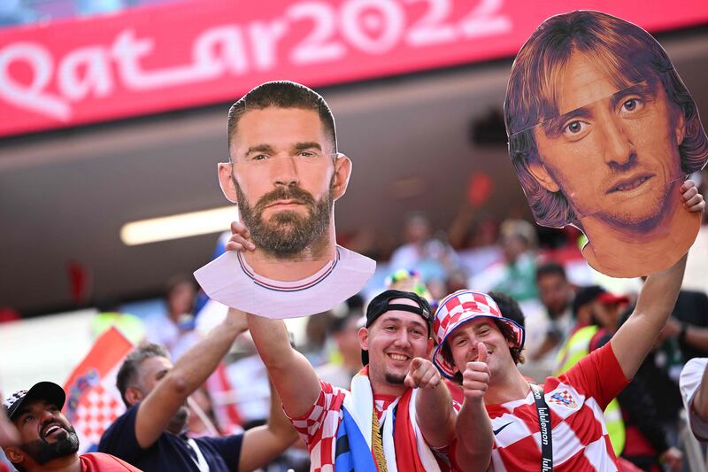 Croatia fans hold aloft cutouts of forward Marko Livaja and midfield legend Luka Modric ahead of the Group F match against Morocco. AFP