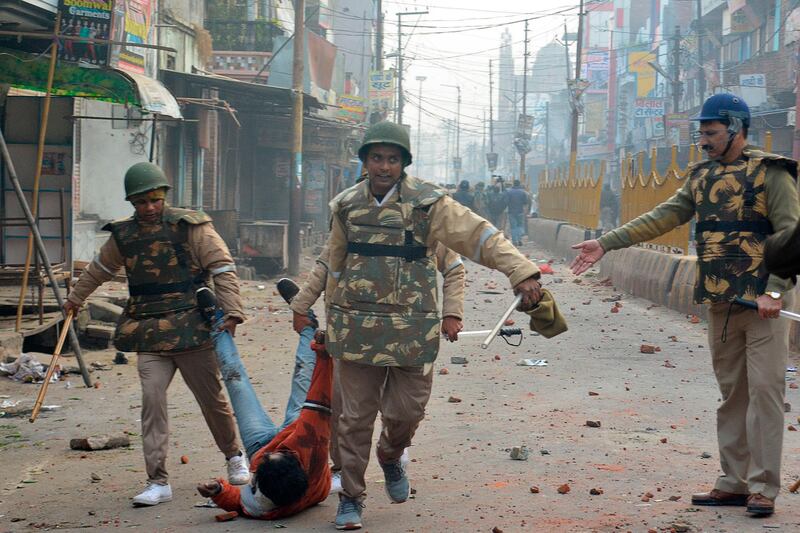 Security personnel detain a protester during demonstrations against India's new citizenship law in Meerut.  AFP