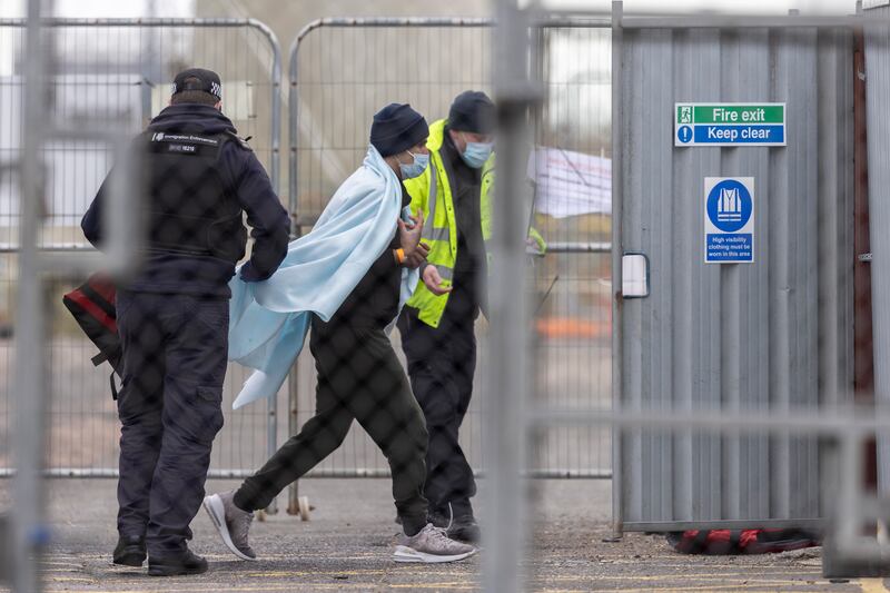 A migrant with UK Border Force personnel. On Thursday, 271 people arrived in the UK on small boats from France. Getty Images