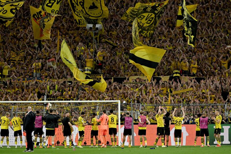 Dortmund's Yellow Wall applauds the players after the victory over PSG. PA