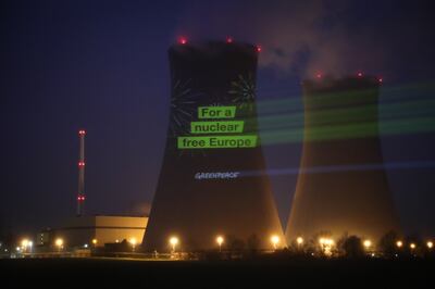 Greenpeace activists project an anti-nuclear slogan onto a German cooling tower at one of the plants disconnected last week. EPA 