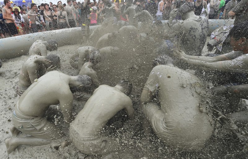 Tourists play with mud in a mud pool. Jung Yeon-Je