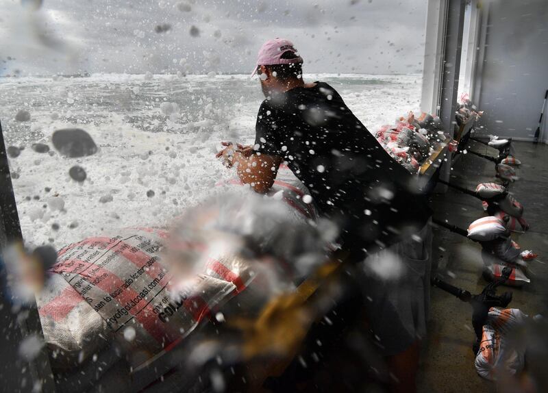 Rick Shores Restaurant owner Nick Woodward is hit by a wave as he sandbags the front of his restaurant in an attempt to protect it from the oncoming waves at Burleigh Heads  on the Gold Coast, Australia. Huge swells and high tides are pummelling south-east Queensland beaches as Cyclone Oma sits off the coast. EPA