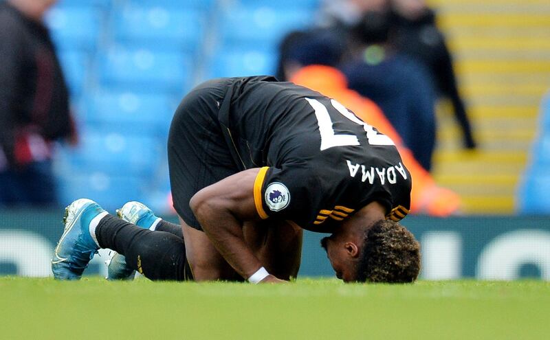 Traore kneels on the pitch after the final whistle. EPA