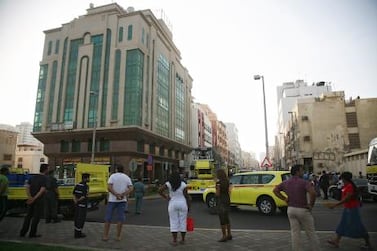 Emergency personnel surrounding the building off 15th Street in Abu Dhabi, where a fire broke out. The National