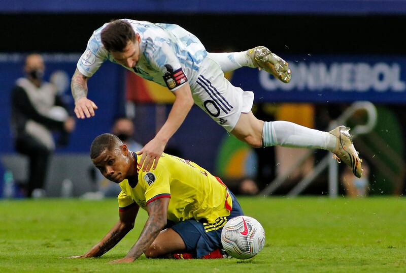 Lionel Messi takes a tumble after a challenge from Colombia's Wilmar Barrios.