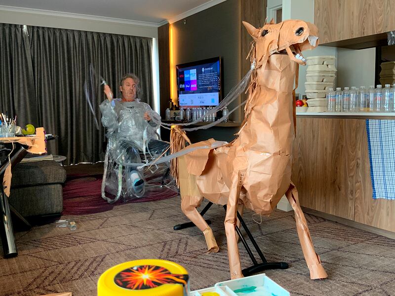 David Marriott poses with his paper horse in his hotel room in Brisbane, Australia, April 6, 2021. While in quarantine inside his Brisbane hotel room, art director Russell Brown was bored and started making a cowboy outfit from the paper bags his meals were being delivered in. His project expanded to include a horse and a clingfilm villain that he has daily adventures with, in images that have gained a huge online following. (David Marriott via AP)