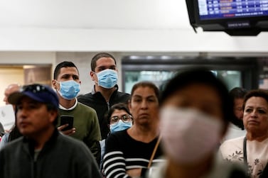 Passengers wearing masks wait at Benito Juarez international airport in Mexico City on January 24. Airlines and airports across the globe are taking precautions following the coronavirus outbreak in China. Carlos Jasso / Reuters
