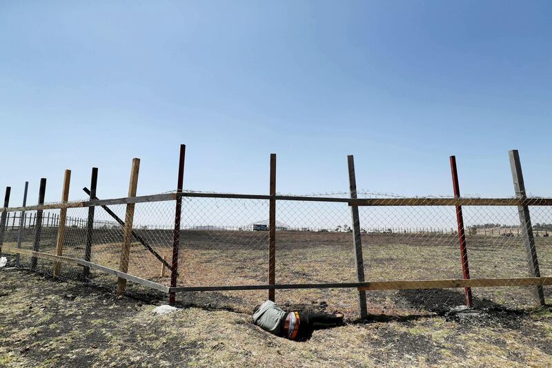 A mourner sleeps next to the fence of the crash site during a memorial service for the victims of the Ethiopian Airlines Flight ET302 plane crash near Bishoftu, Ethiopia. Reuters