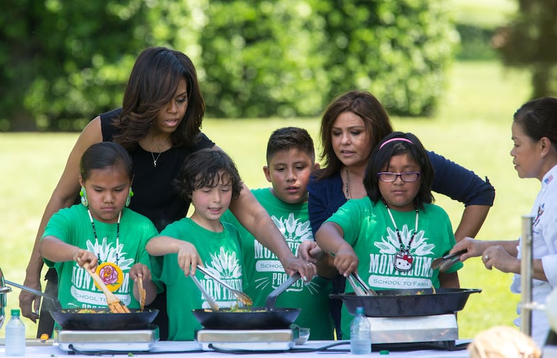 Ms Obama and Rachael Ray, back right, watch Ms Comerford and children preparing a meal in 2016. Photo: Official White House Photo / Amanda Lucidon