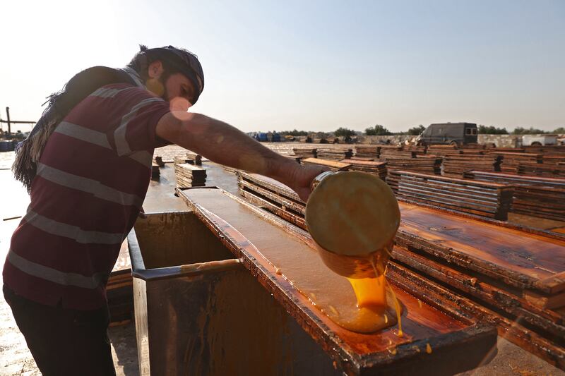 A man pours thickened apricot juice into a mould to make dried strips for the production of Qamar Al Din.