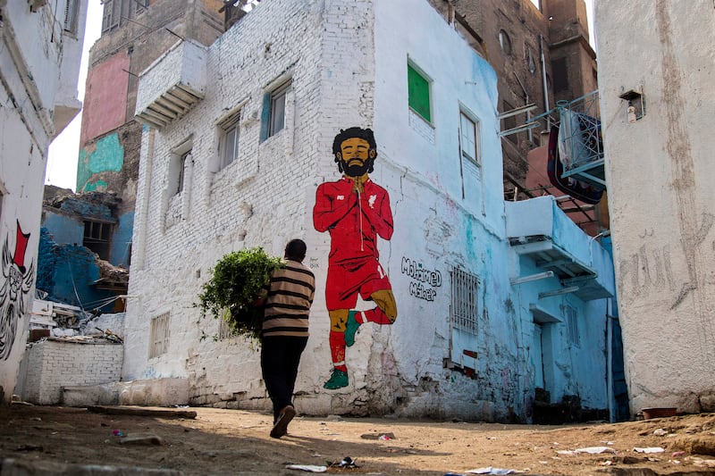 epa07649496 A man walks in front of a mural depicting Liverpool's Egyptian striker Mohamed Salah in Cairo, Egypt, 15 June 2019. The 2019 Africa Cup of Nations (AFCON) will take place from 21 June until 19 July 2019 in Egypt.  EPA/MOHAMED HOSSAM