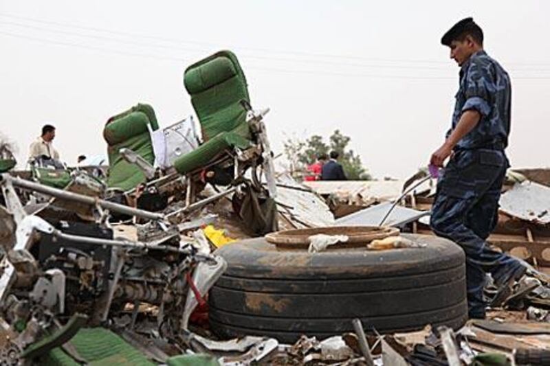 A Libyan policeman walks amid the debris of the Afriqiyah Airways passenger plane which crashed during landing at Tripoli airport.