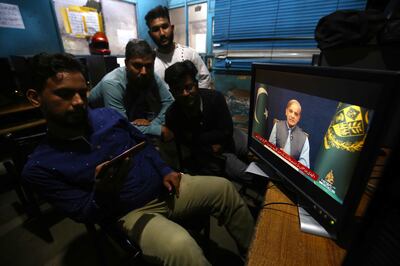 People listen to a televised speech by Pakistani Prime Minister Shehbaz Sharif in Karachi in May. EPA