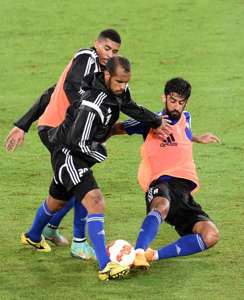 Saeed Al Kathiri (centre) is tackled by Hamdan Al Kamali (right) during a UAE national football team training session at Robina Stadium, Gold Coast, Australia. December 28 2014. Photo Courtesy: UAE FA