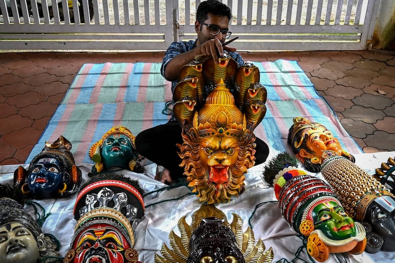 An artisan prepares face masks resembling various Hindu deities for the Kummattikali, a form of colourful mask dance performed as a part of Onam celebrations in Kerala. AFP