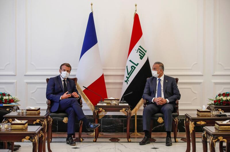 French President Emmanuel Macron (L), mask-clad due to the COVID-19 coronavirus pandemic, meets with Iraq's Prime Minister Mustafa al-Kadhimi (R) in the capital Baghdad on September 2, 2020.   / AFP / POOL / GONZALO FUENTES
