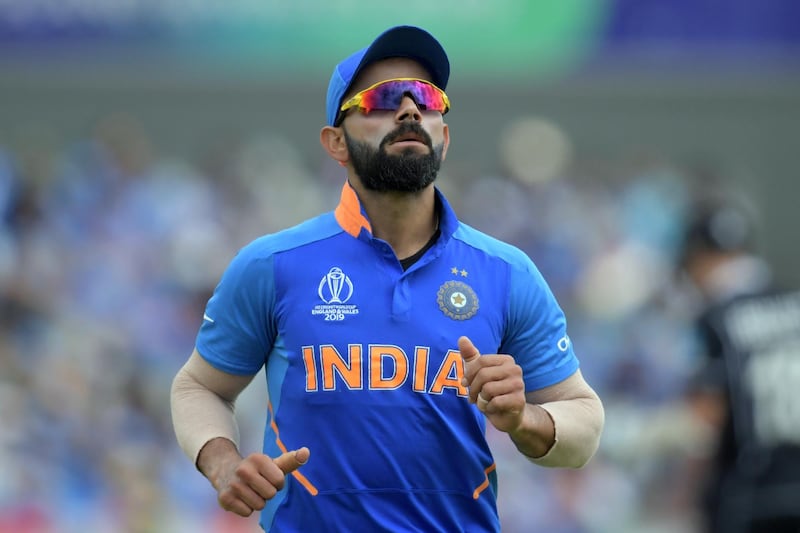 India's captain Virat Kohli jogs on the field during the 2019 Cricket World Cup first semi-final between New Zealand and India at Old Trafford in Manchester, northwest England, on July 10, 2019. (Photo by Dibyangshu Sarkar / AFP) / RESTRICTED TO EDITORIAL USE