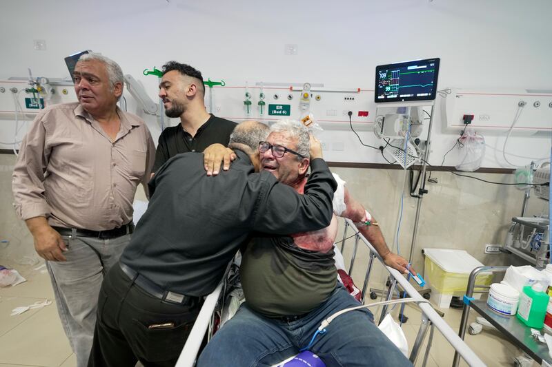 An injured journalist is hugged by one of Abu Akleh's colleagues at the hospital. AP