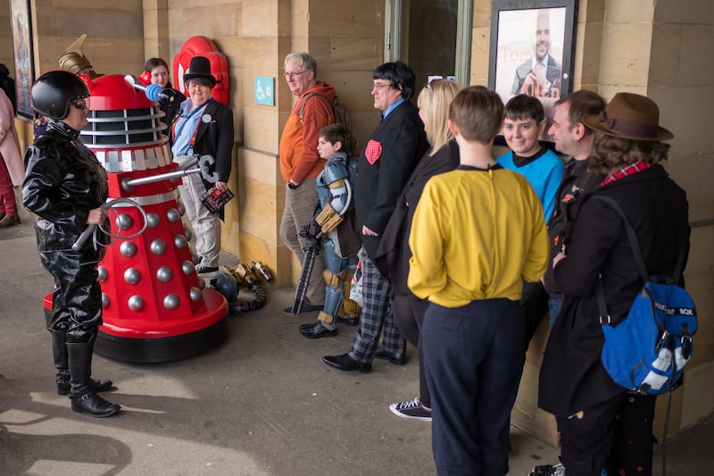 A Dalek talks to members of the public queueing for entry on day two