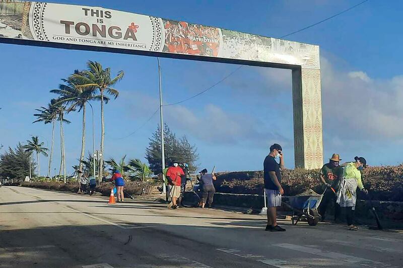 People clear debris off the street in Nuku'alofa, Tonga, following Saturday's volcanic eruption near the Pacific archipelago. AP
