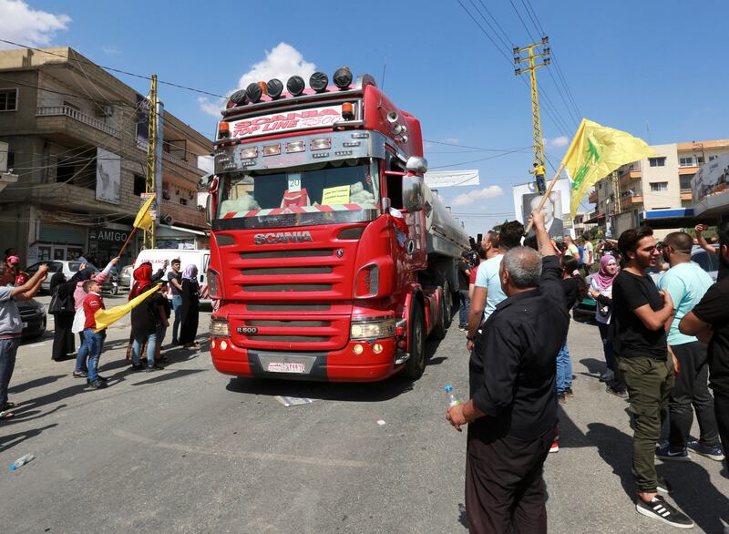 People wave Hezbollah flags as a convoy of tankers carrying Iranian fuel oil arrive in Baalbeck, Lebanon. Reuters