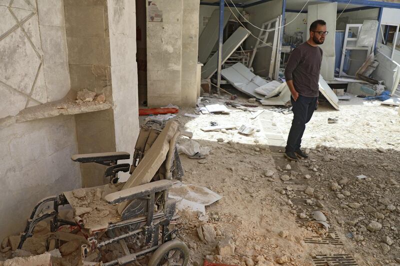 A man stands amid the debris at the entrance of a field hospital in the the village of Atareb in the northern Syrian province of Aleppo on March 21, 2021, after it was reportedly targeted by regime shelling. (Photo by AAREF WATAD / AFP)