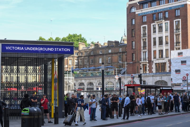 Commuters wait at a bus stop outside a closed Victoria station. Bloomberg