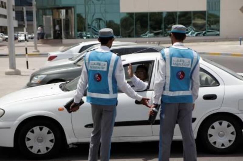 (Abu Dhabi, UAE- June 10, 2012|) Mawaqif officers tell a driver that he is not allowed to park on the side of the road behind the Spinneys Grocery store in Abu Dhabi June 10, 2012. (Sammy Dallal / The National)
