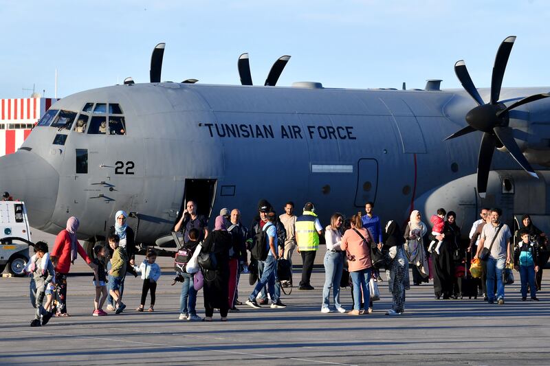Tunisian citizens evacuated from Sudan leave a military aircraft upon their arrival at Tunis-Carthage International Airport. AFP