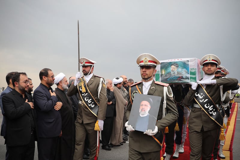 Iranian honour guards carry president Ebrahim Raisi's coffin during a funeral procession at Mehrabad Airport in Tehran. AFP