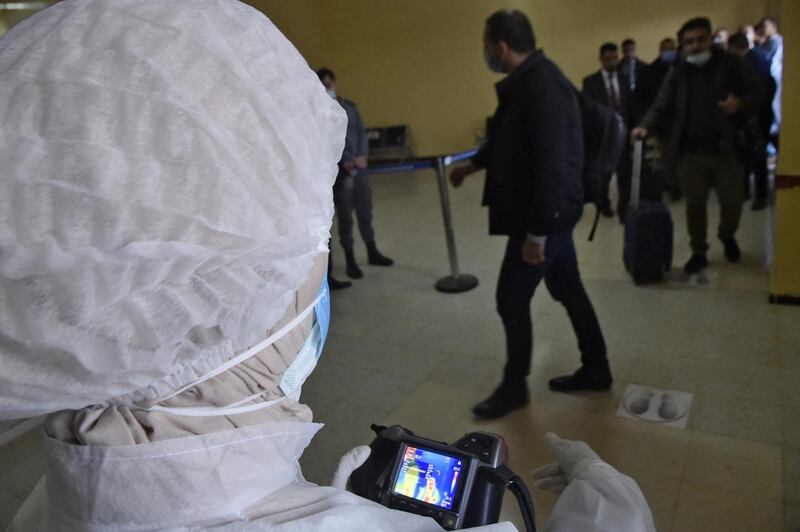 A medical worker measures the temperature of travellers, using a thermal camera, at the arrival hall of Tindouf Airport, in south-west Algeria. AFP