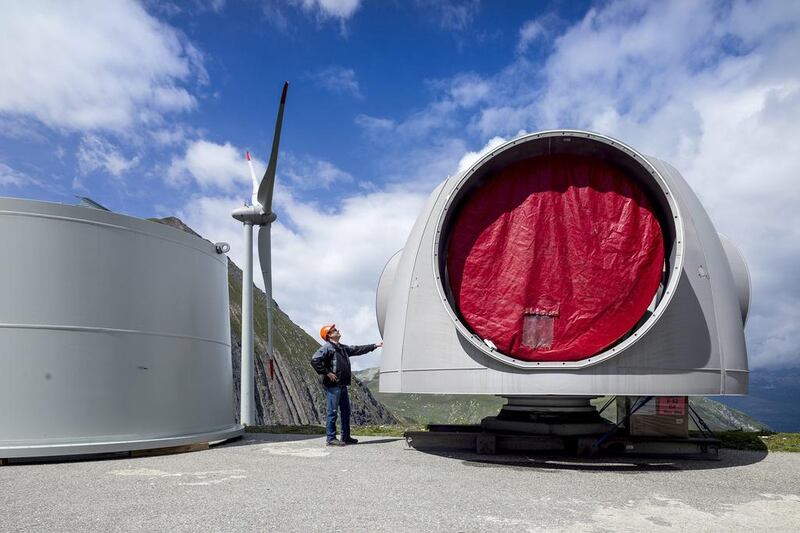 A worker stands next to part of a wind turbine at Griessee lake. Olivier Maire / EPA