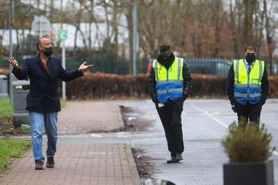 Mohamed Noor, a man who is quarantining, gestures to the security guards while he takes his daily exercises outside the Holiday Inn Hotel near Heathrow Airport, as Britain introduces hotel quarantine programme for arrivals from a "red list" of 30 countries, in London, Britain, February 16, 2021. REUTERS/Hannah McKay