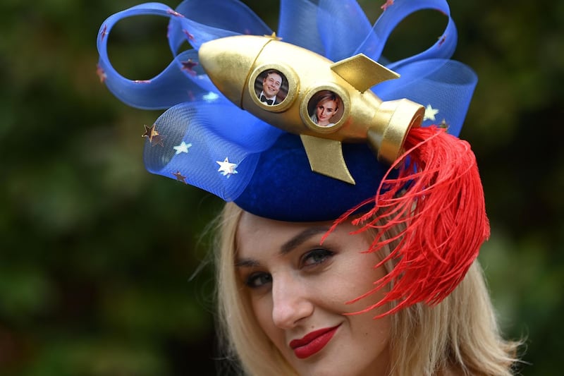 A racegoer poses for a picture wearing an Elon Musk-inspired hat as she arrives to attend Ladies Day at the Royal Ascot horse racing meet, in Ascot, west of London. AFP