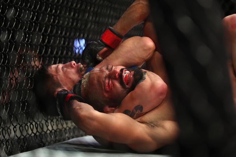 Brandon Moreno applies a choke hold for the victory against Deiveson Figueiredo during their flyweight title mathc at UFC 263.