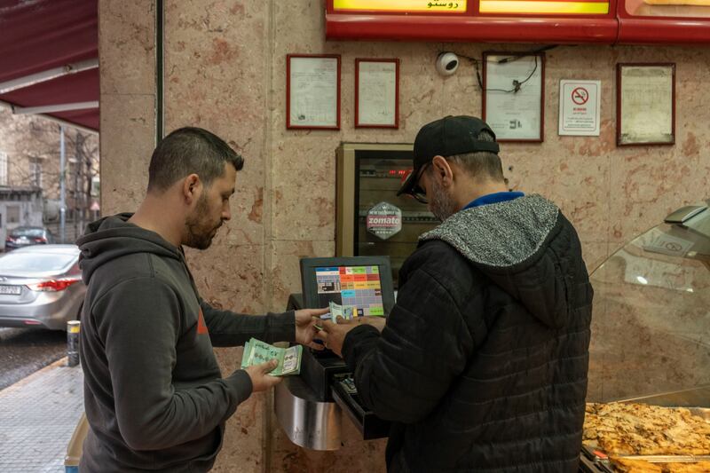A customer pays at a grocery shop in Beirut. Bloomberg