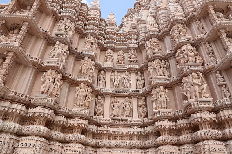 The pink sandstone carvings have been created by artisans from Rajasthan, India, and assembled like a giant jigsaw puzzle on the temple site. Pawan Singh / The National