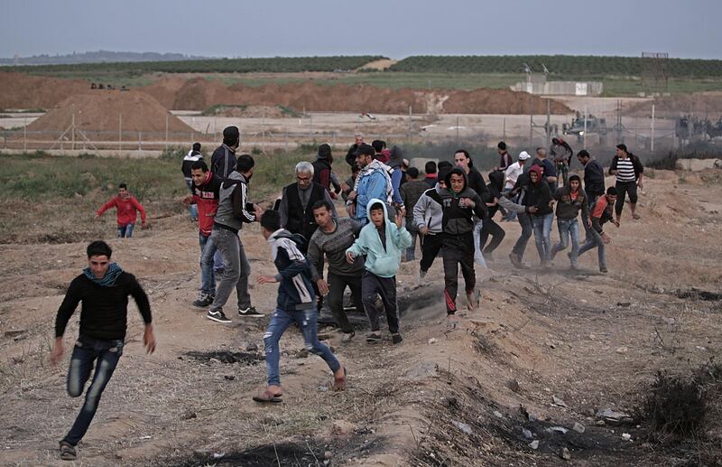 epa06644328 Palestinian protesters run for cover from Israeli shooting during clashes with Israeli troops along the border between Israel and Gaza Strip, in the eastern Gaza Strip, 03 April 2018. Protesters plan to call for the right of Palestinian refugees across the Middle East to return to homes they fled in the war surrounding the 1948 creation of Israel.  EPA/MOHAMMED SABER