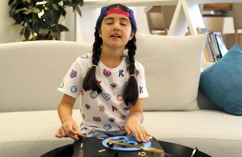 Michelle Rasul enjoys scratching her turntable in the lobby of her apartment building in Dubai, United Arab Emirates, Sunday, May 9, 2021. Rasul, a 9-year-old girl from Azerbaijan who lives in Dubai, is scratching her way to the top as a DJ after competing in the DMC World DJ Championship. (AP Photo/Kamran Jebreili)