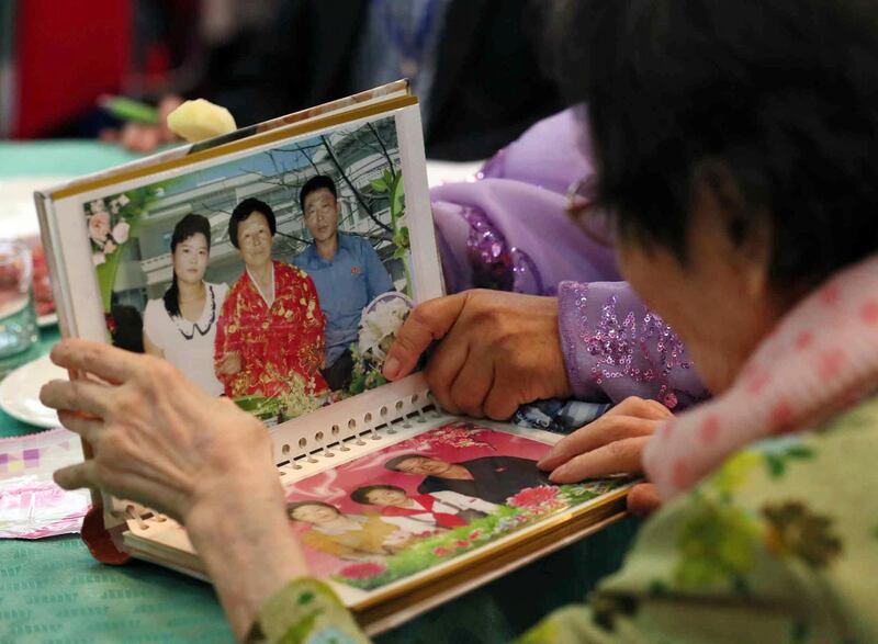 South Korean Han Shin-ja, 99, right, view photos of family members of her North Korean daughters during the Separated Family Reunion Meeting at the Diamond Mountain resort in North Korea, Monday, Aug. 20, 2018. Dozens of elderly South Koreans crossed the heavily fortified border into North Korea on Monday for heart-wrenching meetings with relatives most haven't seen since they were separated by the turmoil of the Korean War. (Lee Ji-eun/Yonhap via AP)