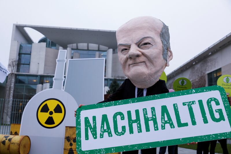 A protester dressed as German Chancellor Olaf Scholz holds a placard reading 'sustainability' in a protest against the EU's nuclear energy plans in Berlin. Photo: Reuters
