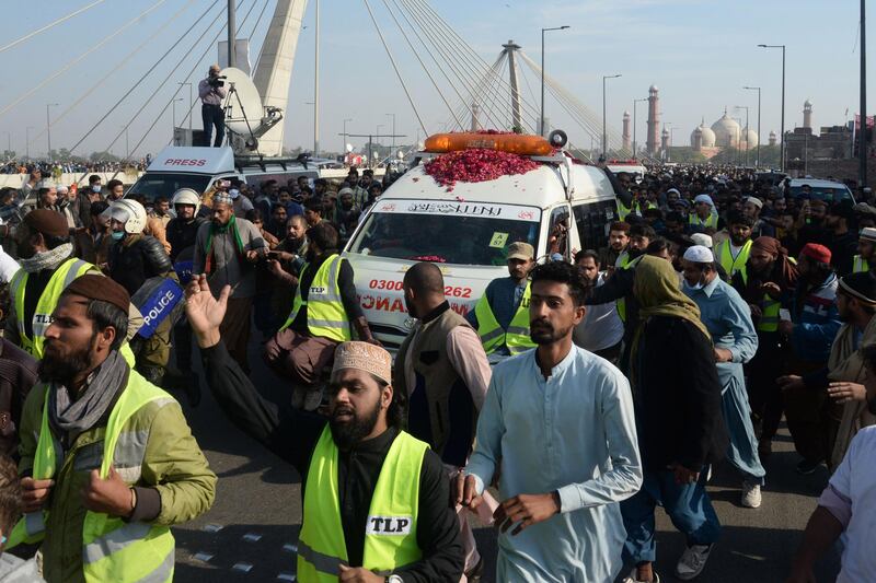 Activists and supporters of Tehreek-e-Labbaik Pakistan (TLP) walk along with an ambulance carrying the coffin of Khadim Hussain Rizvi, founder of TLP, during his funeral procession in Lahore.  AFP