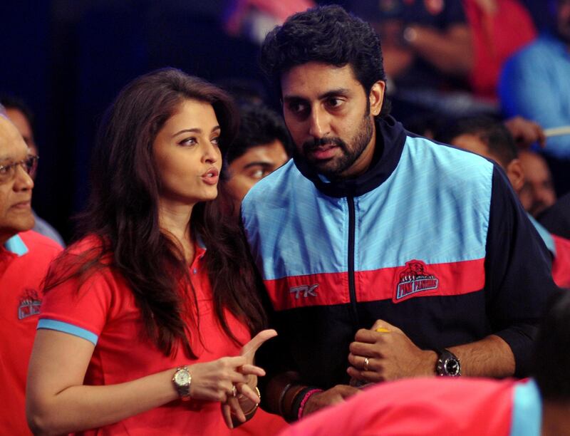 Indian Bollywood actors Aishwarya Rai Bachchan (L) and Abhishek Bachchan talk during a professional kabaddi league match in Mumbai on late July 26, 2014. AFP PHOTO/STR (Photo by STRDEL / AFP)