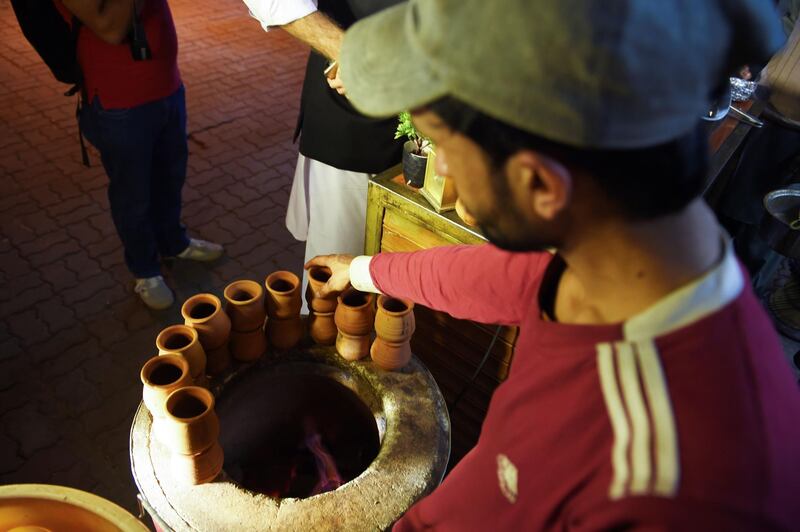 Pakistani people gather to drink tandoori tea in clay pots at a market in Islamabad. It's a cuppa like no other. Every evening in Islamabad a crowd arrives at Sanaullah's street stall to taste his "tandoori chai" - milk tea served in terracotta mugs, still hot from his traditional oven. The old-fashioned cups are placed directly inside the tandoor, where they are baked at high temperatures. Photo: AFP