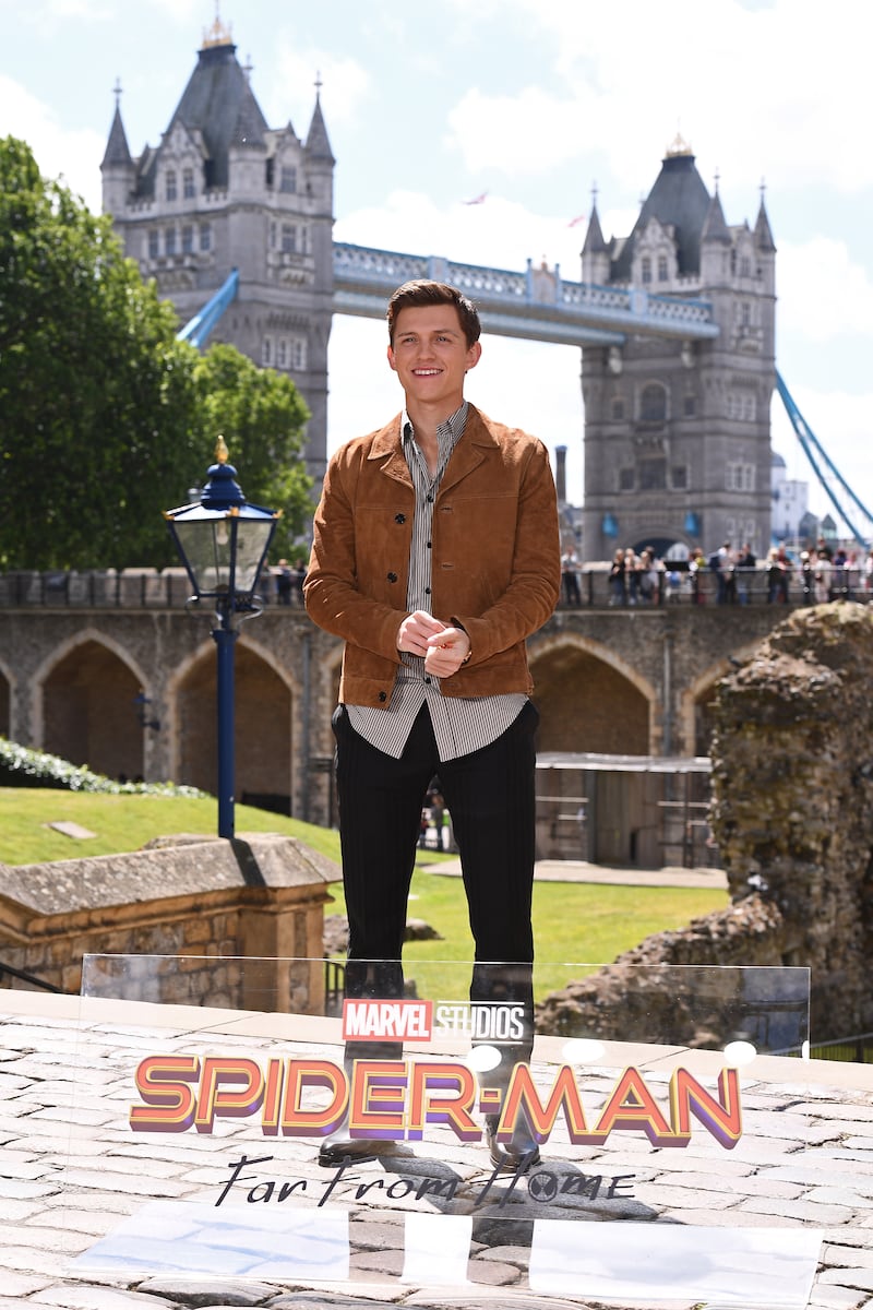 Tom Holland, in a striped shirt and tan suede jacket, attends a 'Spider-Man: Far From Home' photo call in London on June 17, 2019. Getty Images