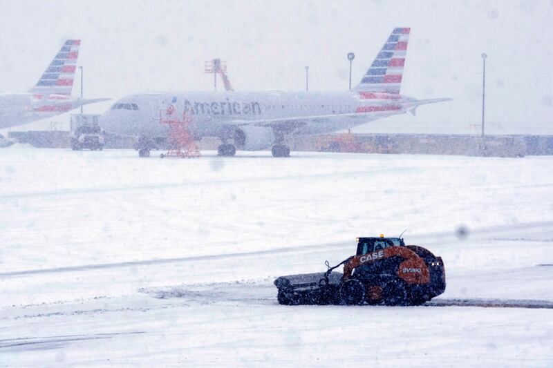 Snow and ice are cleared from the tarmac at Dallas Fort Worth International Airport in Grapevine, Texas. AP