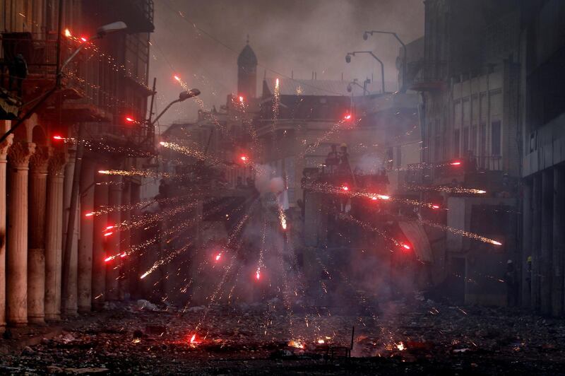 Iraqi demonstrators throw fireworks towards Iraqi security forces during the ongoing anti-government protests in Baghdad. REUTERS